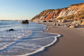 view of aquinnah cliffs from the shore with waves crashing in